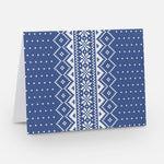 A blue notecard with a traditional Nordic pattern consisting of white floral and geometric designs from The Uff Da Sisters.