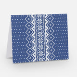 A blue notecard with a traditional Nordic pattern consisting of white floral and geometric designs from The Uff Da Sisters.