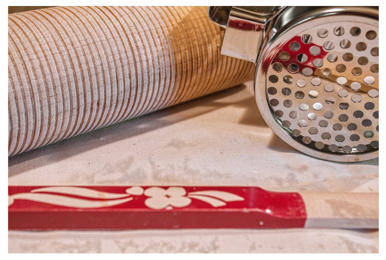 Lefse-making tools — rolling pin, potato ricer, lefse stick.