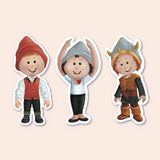 A set of three children's stickers featuring boy gnomes in different costumes: one in a traditional Norwegian bunad with a red hat, another in a Viking outfit with a horned helmet, and the last in a ballet pose wearing a blue beanie and a shirt with a red heart. Each sticker is outlined to show it's a peelable sticker.