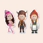 A collection of three stickers featuring girl characters in various costumes. From left to right, there's a girl in a pink ballet outfit with a matching bow, a girl dressed as a shieldmaiden in Viking armor with a helmet, and a girl wearing a traditional Norwegian bunad with a red hat. Each character is smiling and presented against a clear background, ready to be peeled off and used.