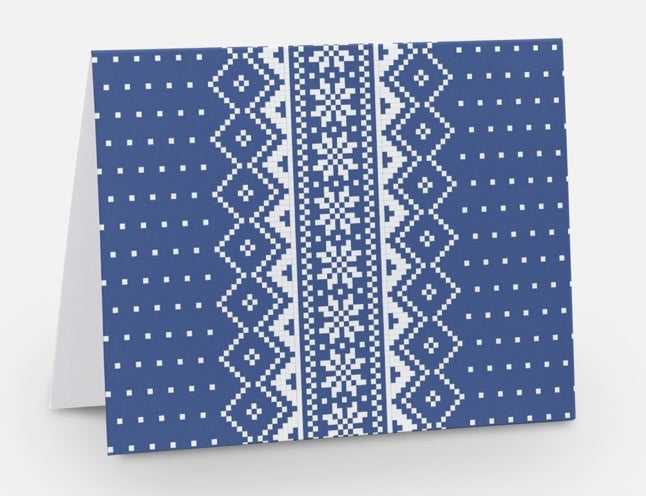  A blue notecard with a traditional Nordic pattern consisting of white floral and geometric designs from The Uff Da Sisters.