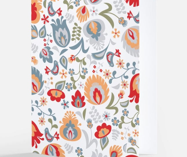  A notecard featuring a multicolored Nordic floral pattern with a mix of flowers and leaves in red, blue, orange, and grey tones on a white background, from The Uff Da Sisters.